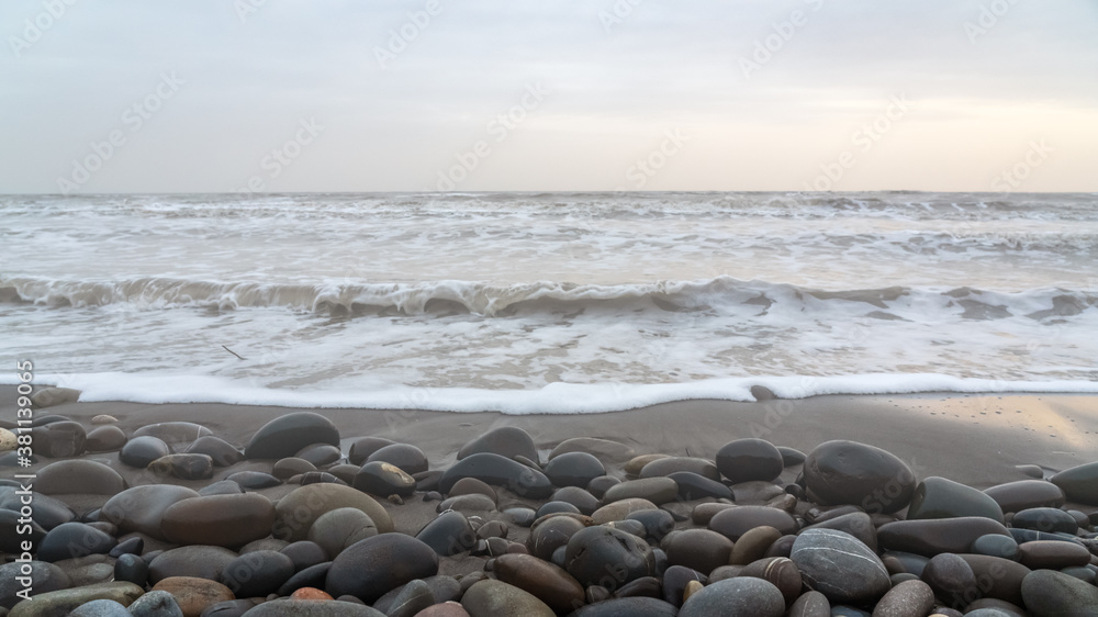 Pebbles on beach washed by waves at foggy weather Pebbles on beach washed by waves at foggy weather