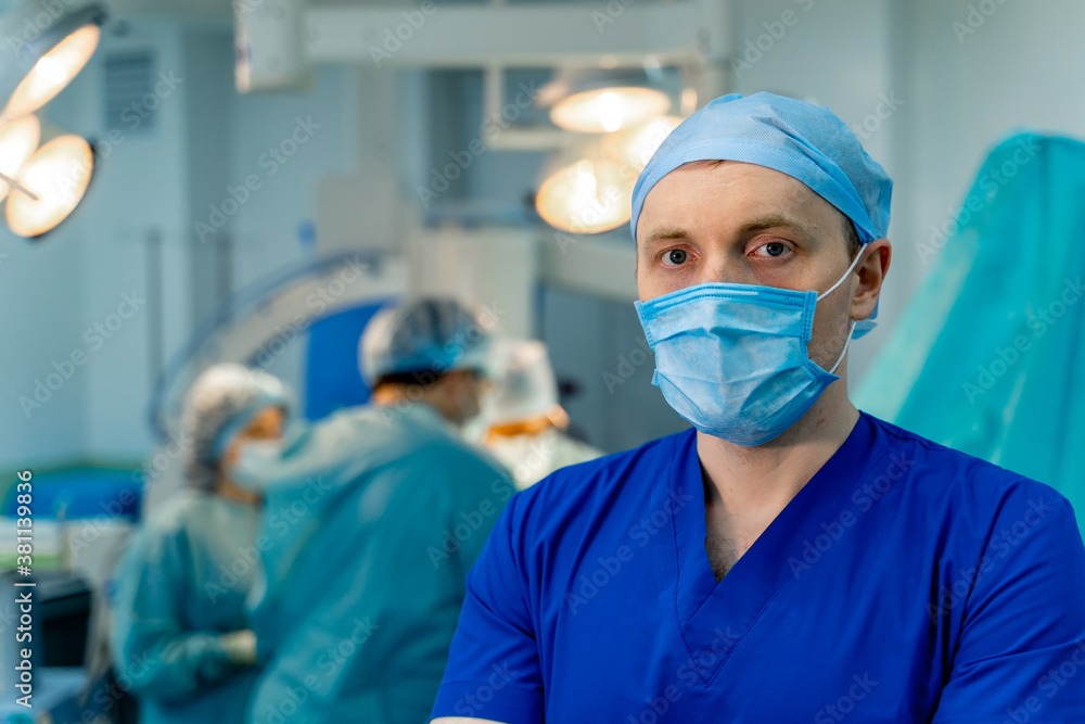 Male doctor or assistant is standing in an operation room. Medical background. Medic in scrubs. Male doctor or assistant is standing in an operation room. Medical background. Medic in scrubs.