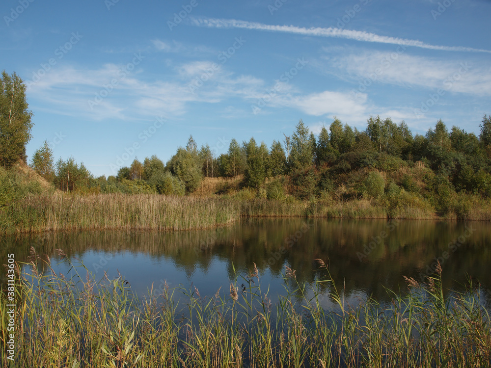 Autumn landscape. Autumn sky and forest reflected in the water surface of the pond. Autumn landscape. Autumn sky and forest reflected in the water surface of the pond.