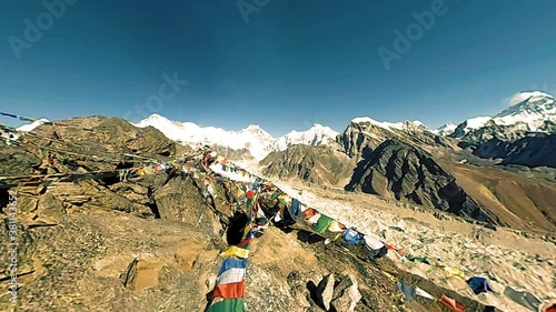 Gokyo Ri mountain top. Tibetan prayer Buddhist flag. Wild Himalayas high altitude nature and mount valley. Rocky slopes covered with ice. Panorama movement 180 degree