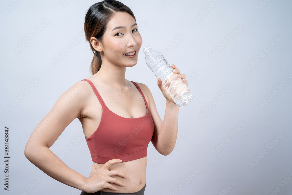 Asian woman in red workout clothes with bottle of water, isolated on white background. Asian woman in red workout clothes with bottle of water, isolated on white background.