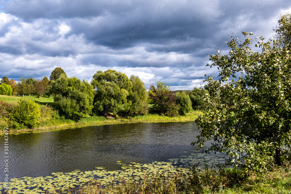 Fototapeta premium landscape with green meadows white ancient church against the backdrop of a stormy sky