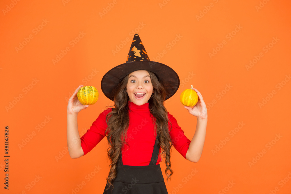 funny child in witch costume hat for Halloween with pumpkin or squash on orange background, jack o lantern funny child in witch costume hat for Halloween with pumpkin or squash on orange background, jack o lantern
