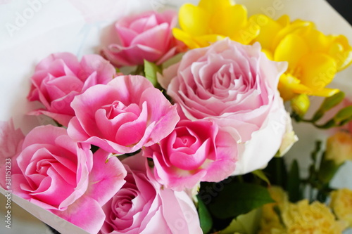 ピンク色のばらと黄色いフリージアの花束