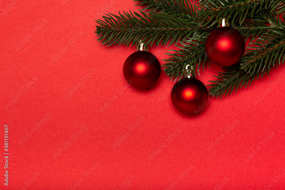 Obraz premium Red Christmas balls with Christmas tree on red background. Flat lay, top view, copy space. Christmas banner