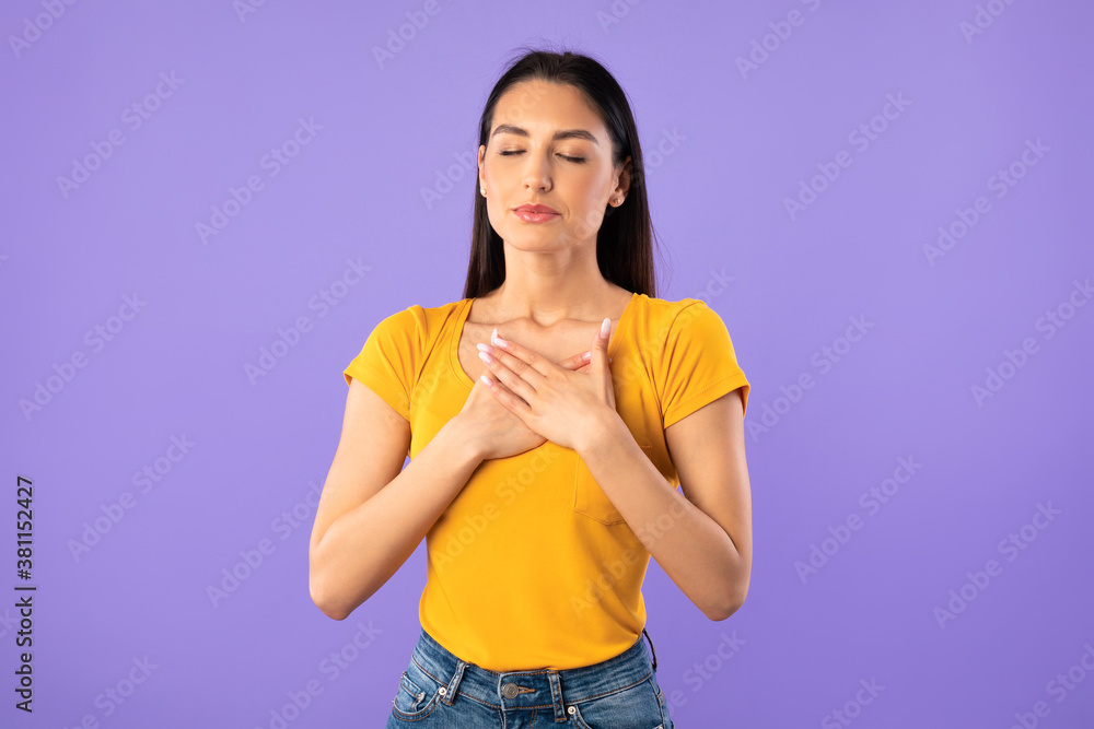 Woman with closed eyes keeping hands on chest Woman with closed eyes keeping hands on chest