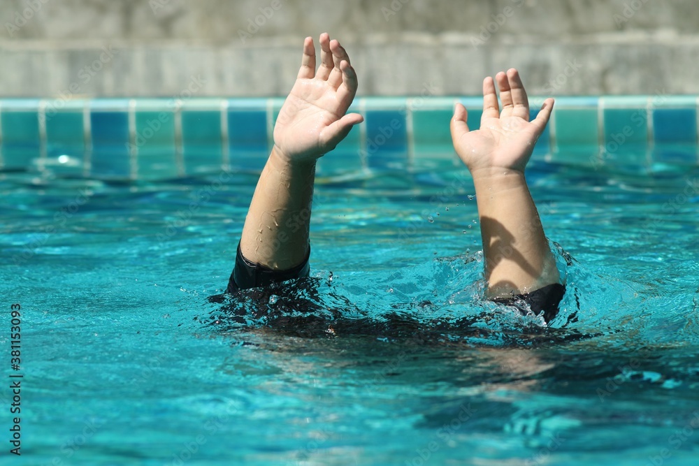 A child is drowning raise his hand for help.