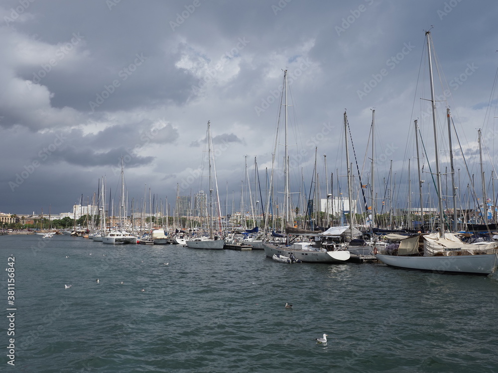 BARCELONA, SPAIN on SEPTEMBER 2019: View to yachts in port of european city at Catalonia district, cloudy sky in cold summer day.