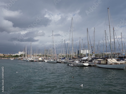 BARCELONA, SPAIN on SEPTEMBER 2019: View to yachts in port of european city at Catalonia district, cloudy sky in cold summer day.