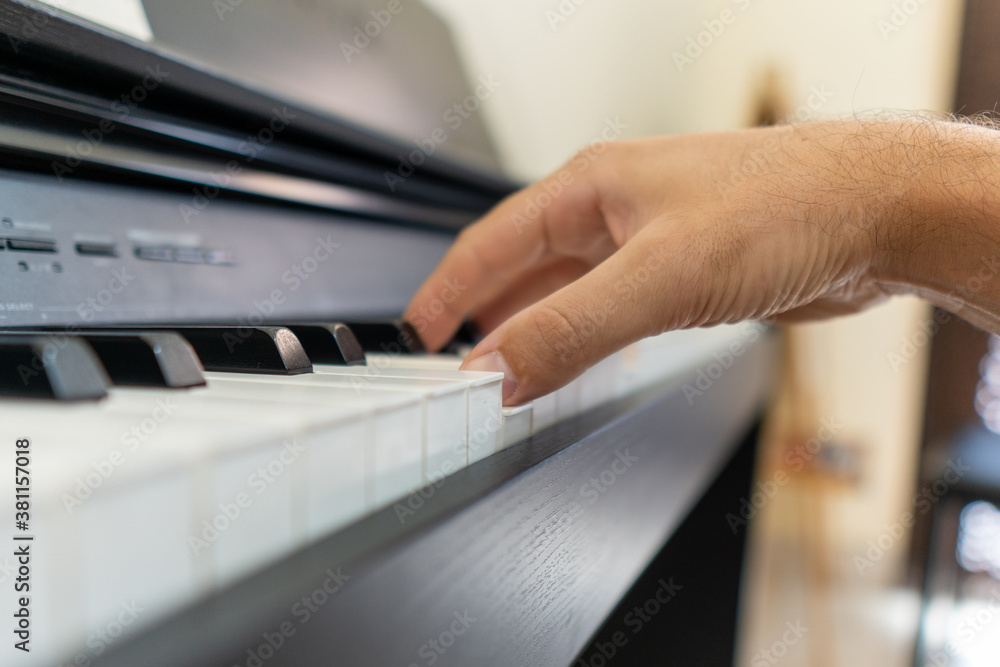Caucasian Hand playing the piano making music close up