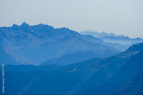 blurred abstract natural background with Caucasus Mountains in a morning blue mist © dvulikaia