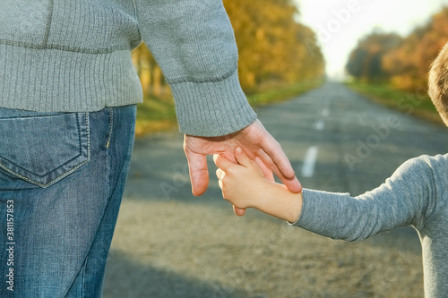 A Happy parent with child are walking along the road in the park on nature travel