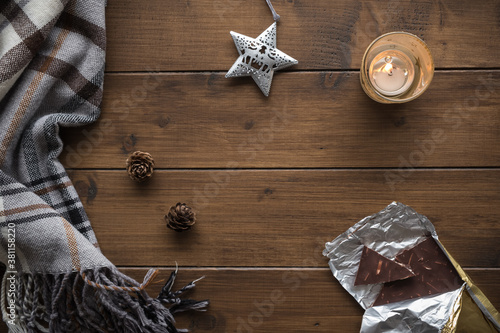 Christmas or winter background with a plaid, fir cones, Christmas tree decoration and chocolate, top view