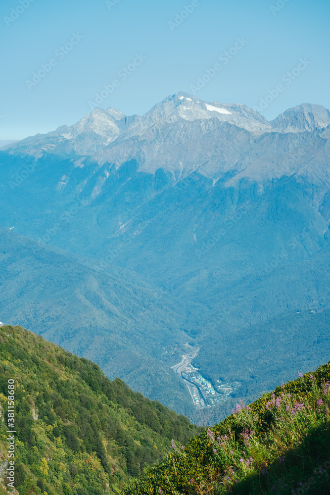 Fototapeta premium natural wallpaper with high mountains in fog and green hill