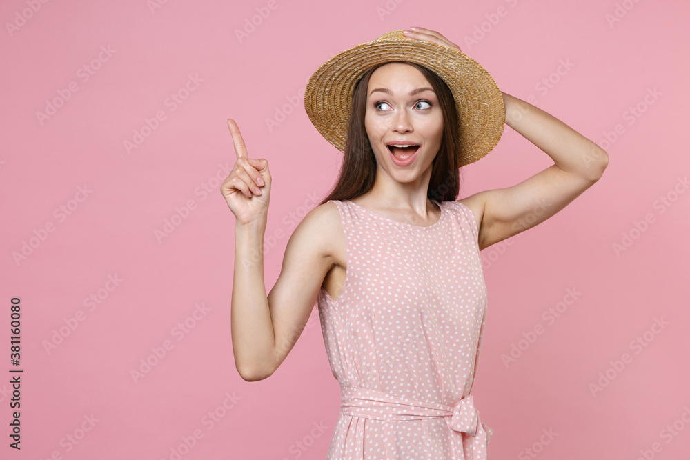 Excited young brunette woman 20s wearing pink summer dotted dress hat posing pointing index finger up on mock up copy space put hand on head isolated on pastel pink color background studio portrait. Excited young brunette woman 20s wearing pink summer dotted dress hat posing pointing index finger up on mock up copy space put hand on head isolated on pastel pink color background studio portrait.