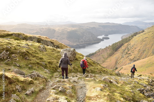 Three people trekking together down a path in Helvelln Lake Dsitrict