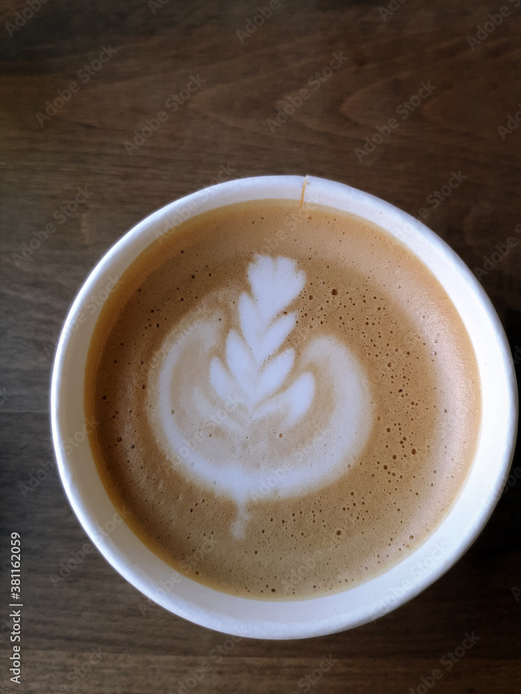 top view fresh coffee with milk foam art on a wooden background top view fresh coffee with milk foam art on a wooden background