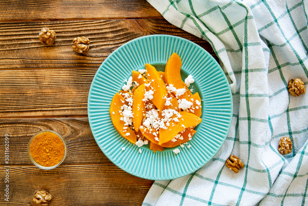 Tasty autumn pumpkin salad with cheese on rustic background. Beautiful fall colors. Tasty autumn pumpkin salad with cheese on rustic background. Beautiful fall colors.