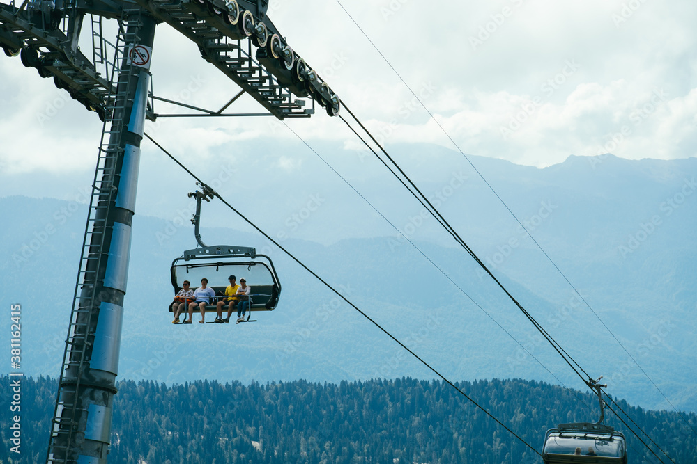 Sochi, Russia, 17 September 2020 - tourist moving in cable car on a blurred background of high mountains in blue haze at the morning Sochi, Russia, 17 September 2020 - tourist moving in cable car on a blurred background of high mountains in blue haze at the morning