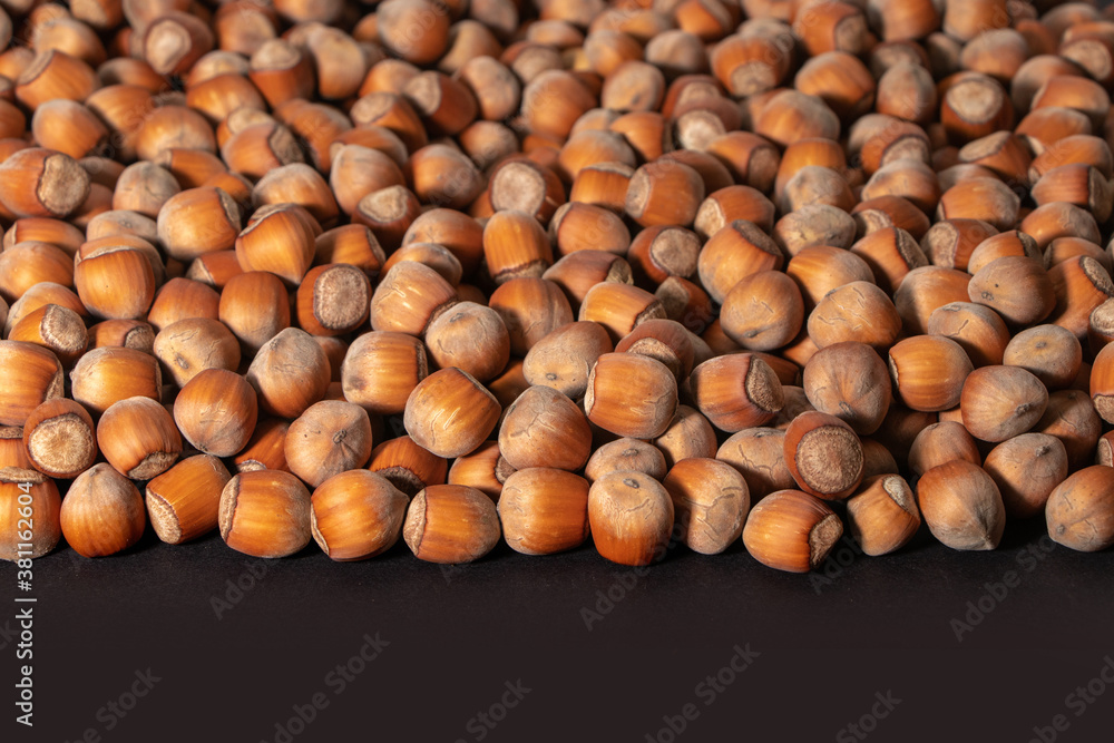 Hazelnuts. Stack of hazelnuts. Food background. Hazelnut on darck background Hazelnuts. Stack of hazelnuts. Food background. Hazelnut on darck background