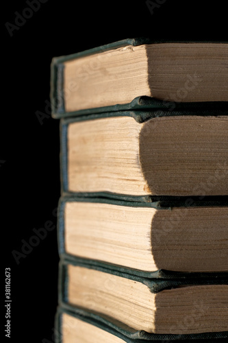A stack of old books on a black background.