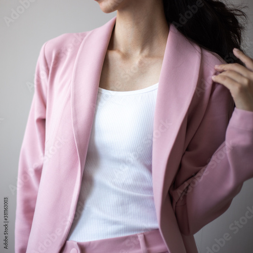 Closeup photo of young woman wearing pink costume. Parts of body over simple background © cherry_d