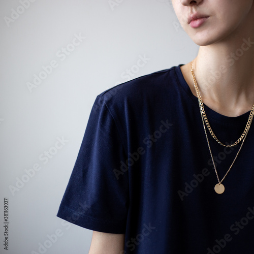 Closeup photo of yping woman wearing dark t-shirt and golden necklace photo