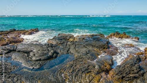 Beautiful shore. Large boulder among the waves in the sea. Hawaii