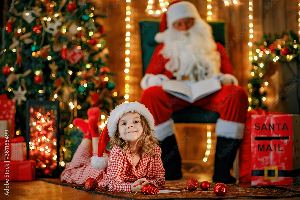 Merry Christmas, santa claus and little child girl at night at the Christmas tree. Merry Christmas, santa claus and little child girl at night at the Christmas tree.