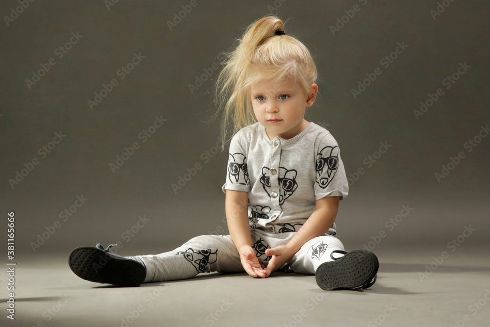 Naklejka premium Studio shot of 3 years old fashionable kid on the grey background 