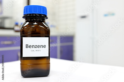 Selective focus of benzene liquid chemical compound in dark glass bottle inside a chemistry laboratory with copy space. Aromatic hydrocarbon used in petrochemical industry.	 photo