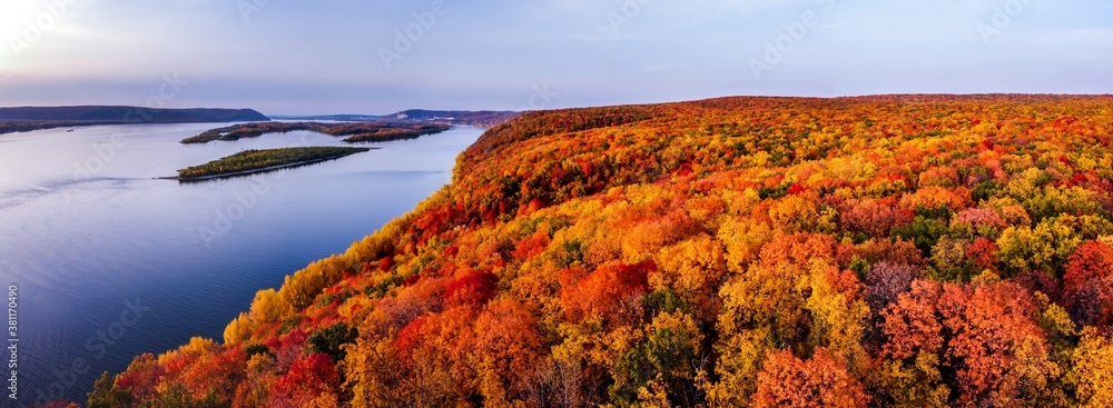 Aerial panoramic landscape view on Volga river with small sand islands and colorful forest on hills during autumn sunset, Samara, Russia