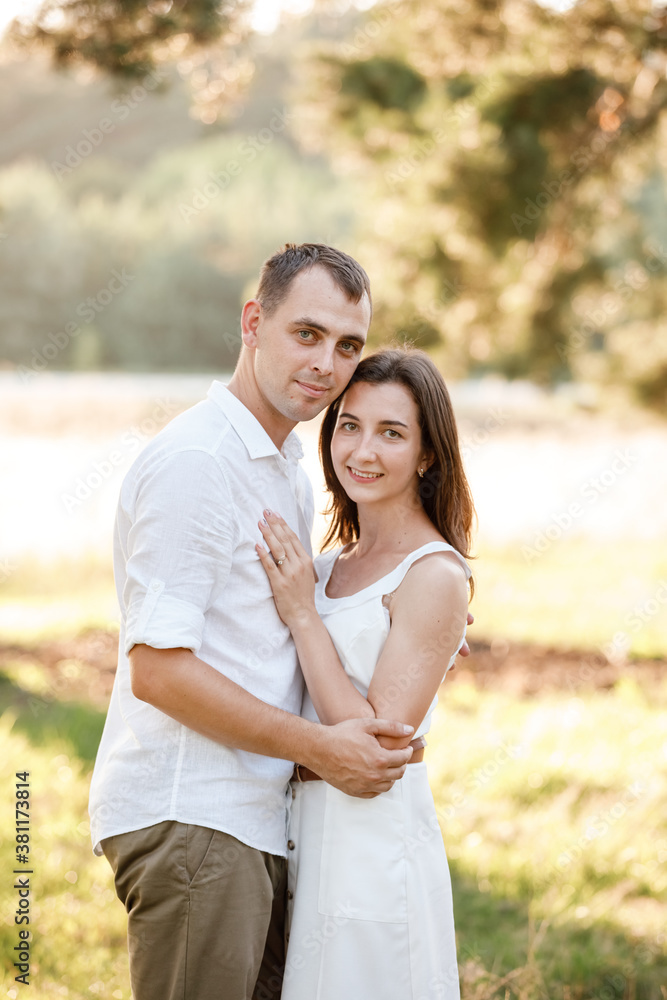 beautiful young couple are hugging in the summer park. stylish man and woman having fun outdoors. family day concept. copy space. beautiful young couple are hugging in the summer park. stylish man and woman having fun outdoors. family day concept. copy space.