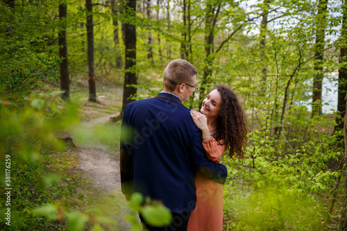 Romantic walk of a young couple in a green forest, warm spring weather. Guy and girl hugging in nature © Дмитрий Ткачук