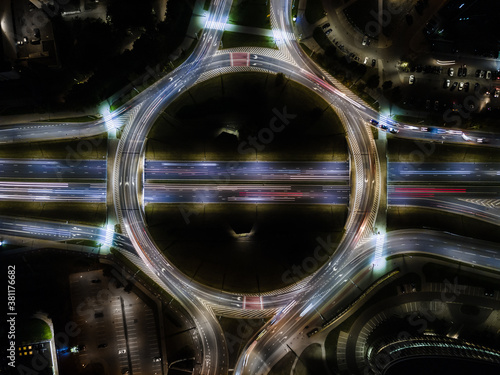 Elevated road junction with roundabout and interchange overpass at night from above Fototapet