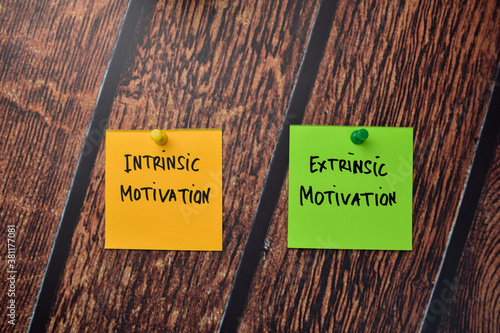 Intrinsic Motivation and Extrinsic Motivation write on sticky notes isolated on office desk. photo