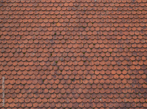 Tiled roof in Europe, Germany. Travel picturesque background and texture photo. Detailed view of wet old red roof shingles. Colorful photo