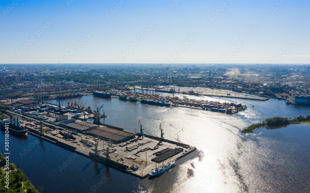 Fototapeta premium Aerial view of cargo ship, cargo container in warehouse harbor in the Morskie Vorota district in St. Petersburg