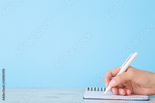 Фотография Young woman hand writing daily plan, important information, ideas, memories or other text