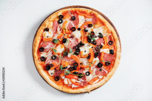 Italian pizza with olives, peppers and herbs on white background.