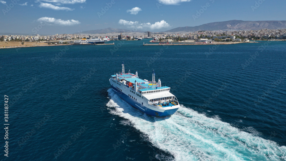 Aerial drone photo of passenger ferry cruising in high speed and entering famous port of Piraeus, Attica, Greece