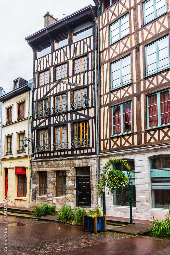 Naklejka premium Typical Old Half-timbered houses at Rue Eau de Robec in Rouen on a rainy day. Rue Eau-de-Robec is one of the main tourist streets of Rouen. Upper Normandy, France.