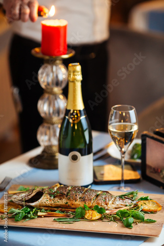 Roasted sea bass with herbs on the served table