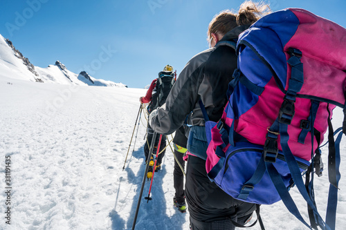 Rope team member point of view with mountaineers walking on snow and ice in sunny weather. © anzebizjan