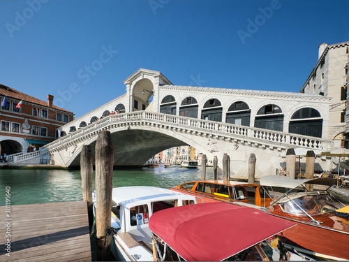 The Grand Canal and Rialto bridge, Venice, Italy with water taxi boats in front.