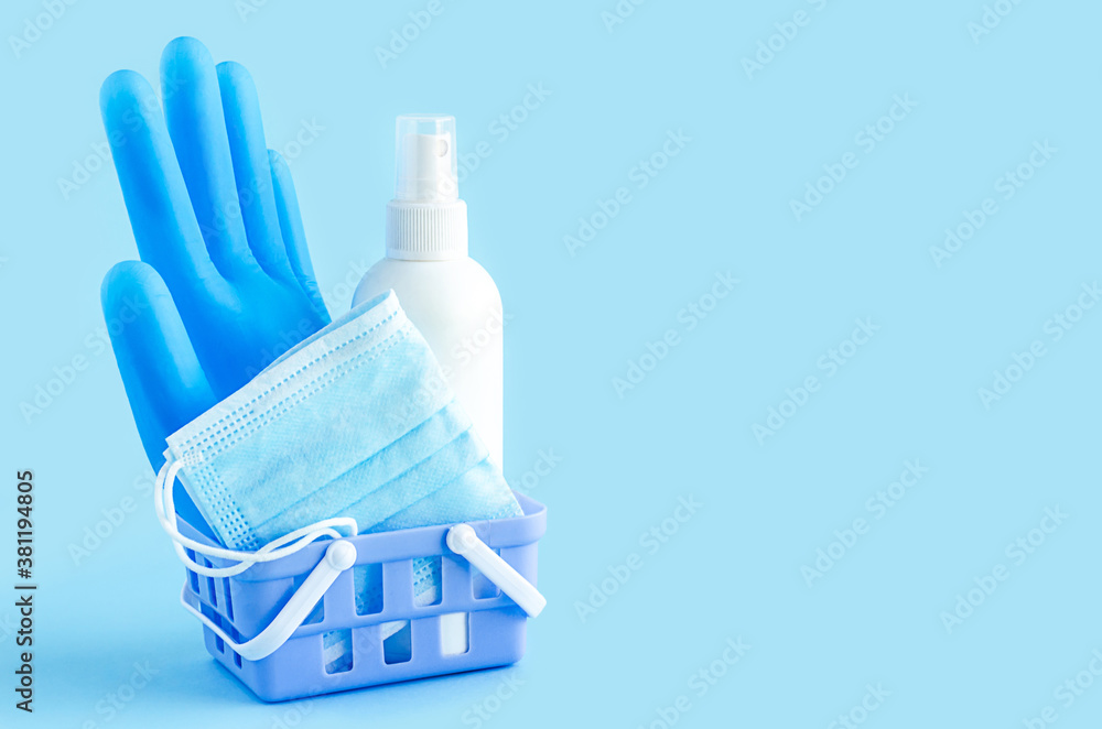 home ordering, personal protective equipment in quarantine. gloves, mask, sanitizer in basket on blue background, copy space, text. delivery, online purchase of medicines. covid-21 home ordering, personal protective equipment in quarantine. gloves, mask, sanitizer in basket on blue background, copy space, text. delivery, online purchase of medicines. covid-21