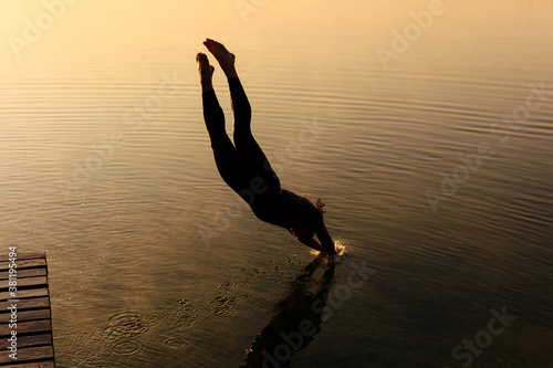 Εκτύπωση καμβά Strong muscular guy plunge into water from wooden pier
