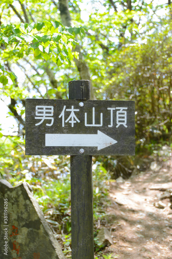 Tsukuba, Japan: A wooden signboard written in Japanese showing the path to the mountain peak. It translated as 