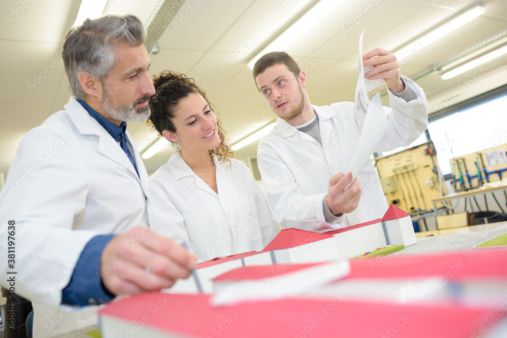 Obraz premium students and teacher stood around scale model