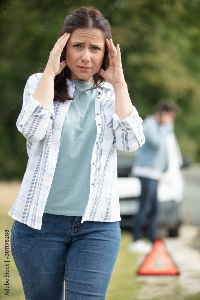 Fototapeta premium woman looking stressed after breakdown on street